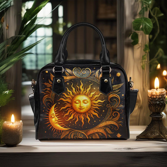 Black handbag with sun and moon design on a wooden surface with candles and plants.